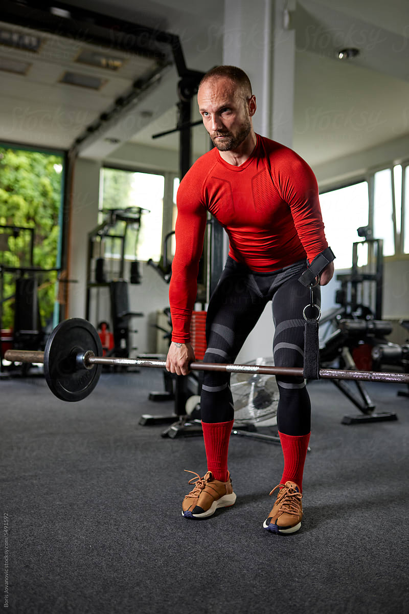 Strained man with a disability practicing a deadlift