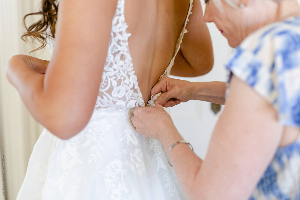Mother Buttoning the Back of a Wedding Dress