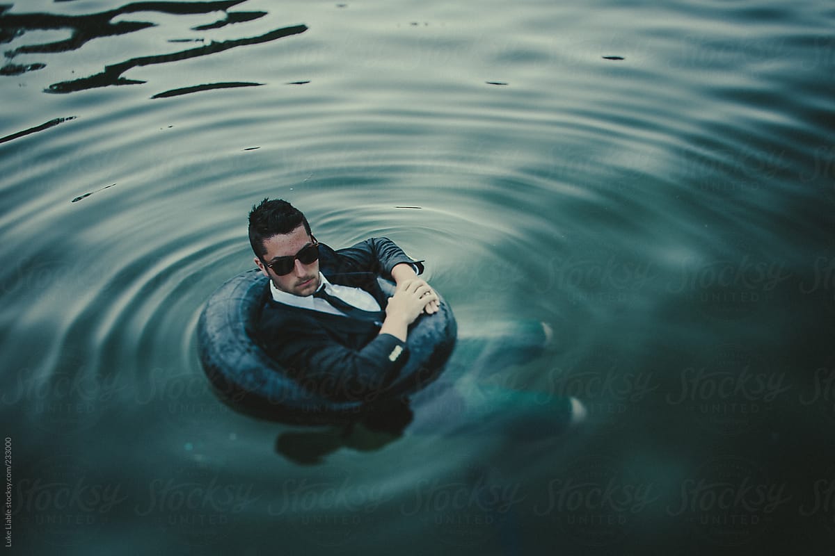 Man in suit floating in water in a tube