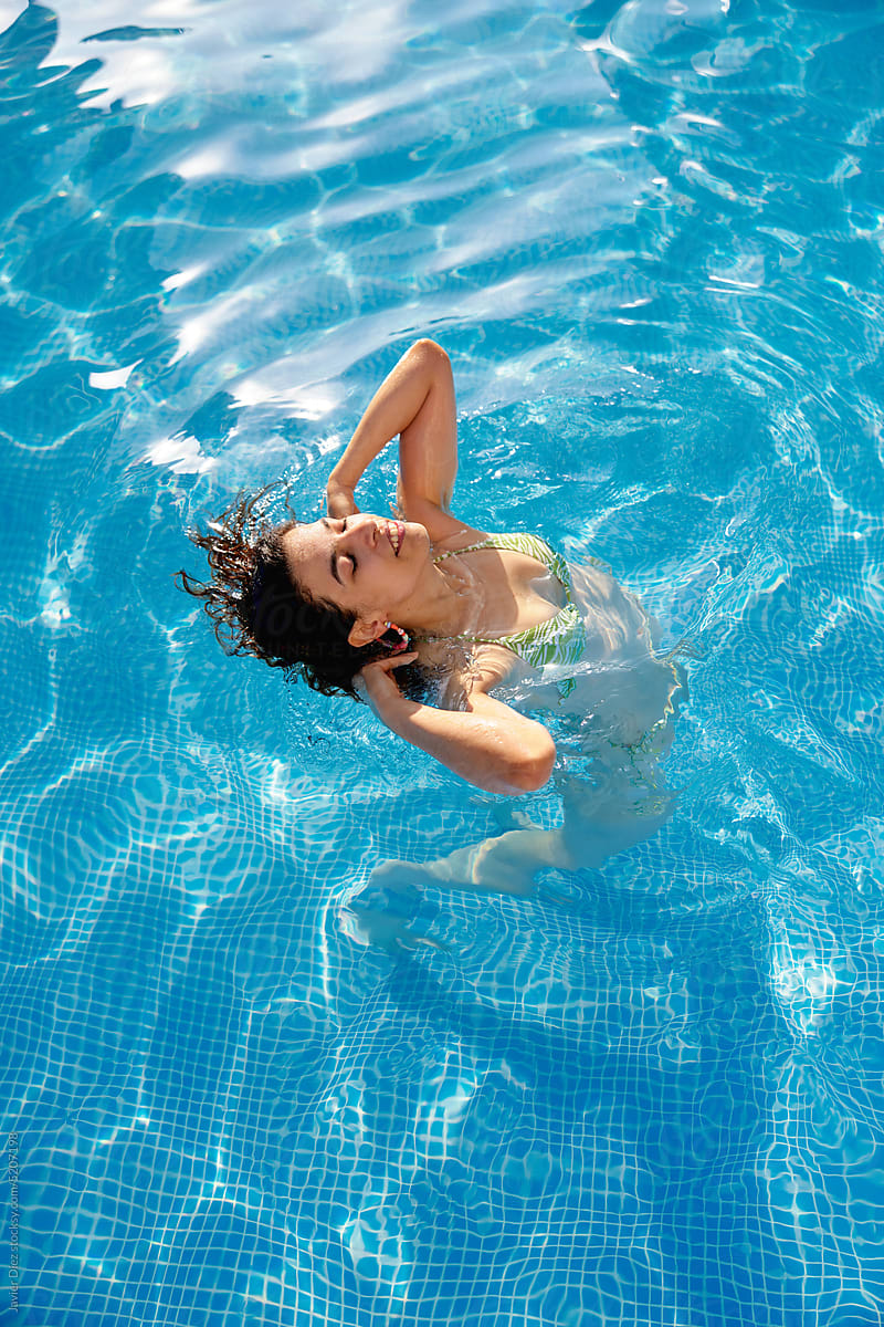 Calm woman swimming in pool water