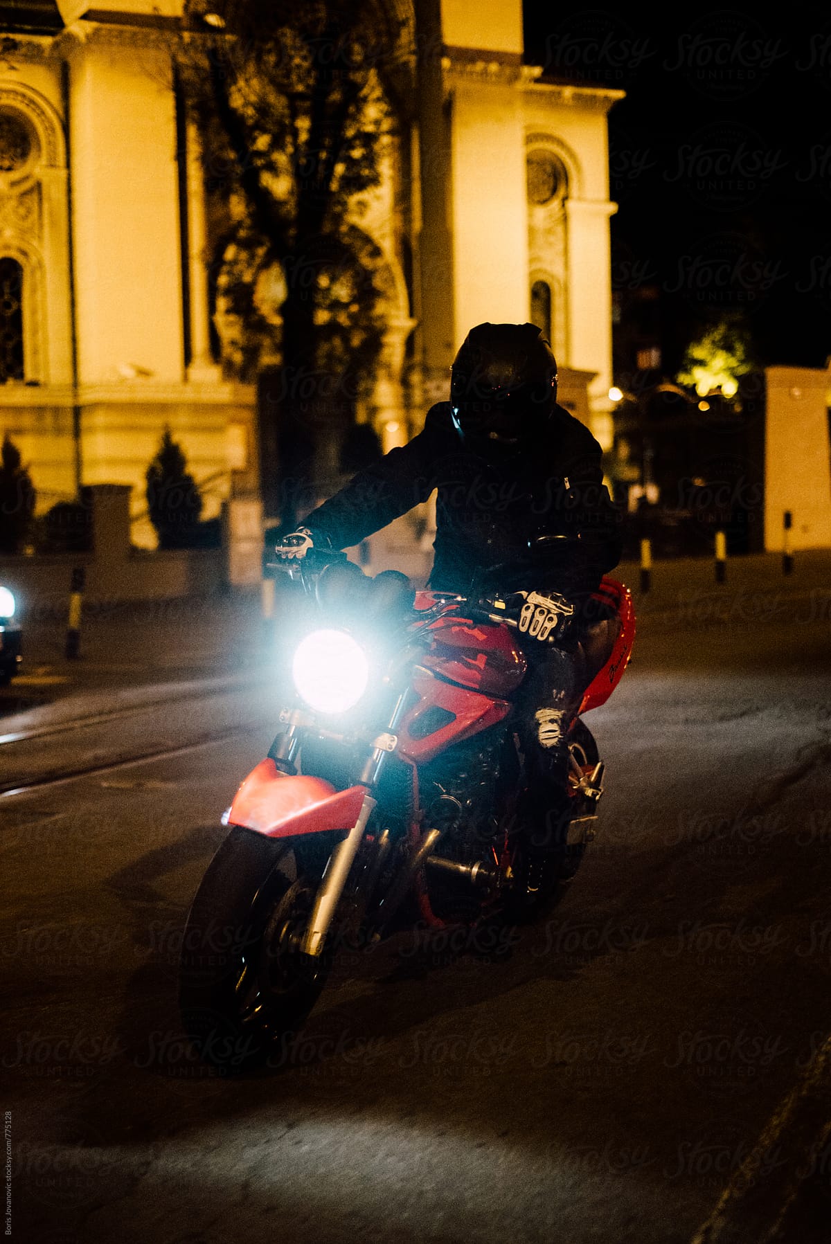 Biker riding a motorcycle on the street at night