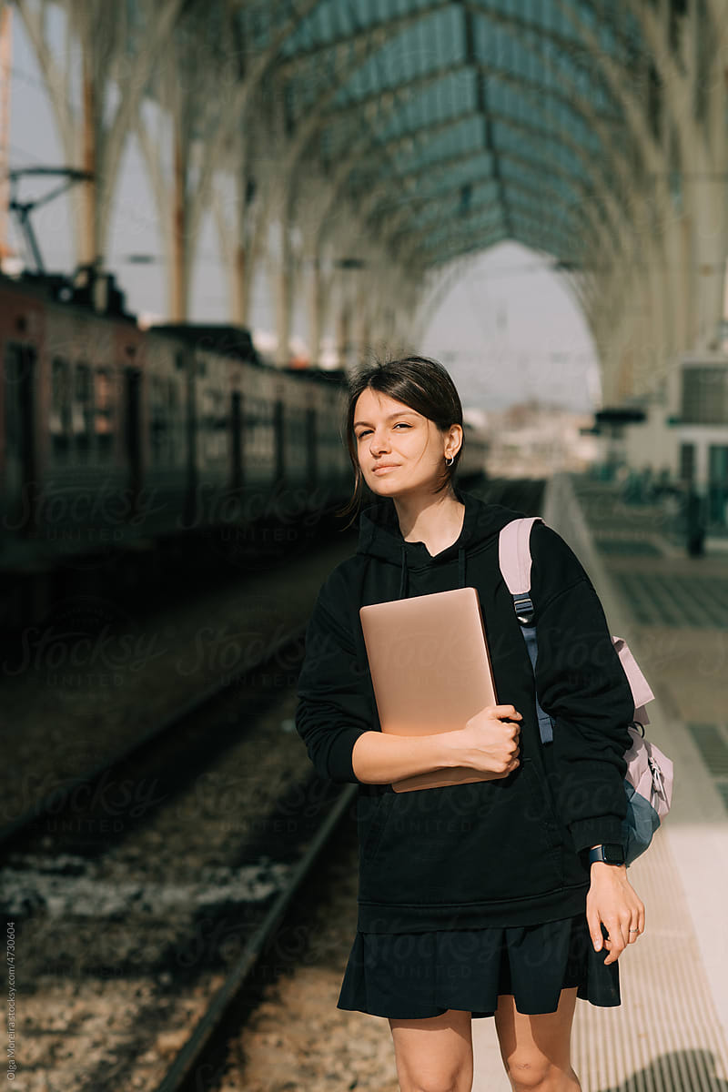 Student with laptop waiting for train