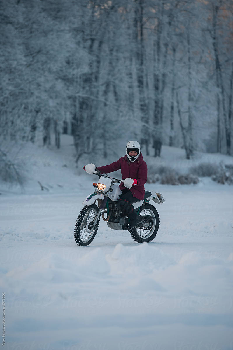 young woman learning to ride enduro motorbike in winter
