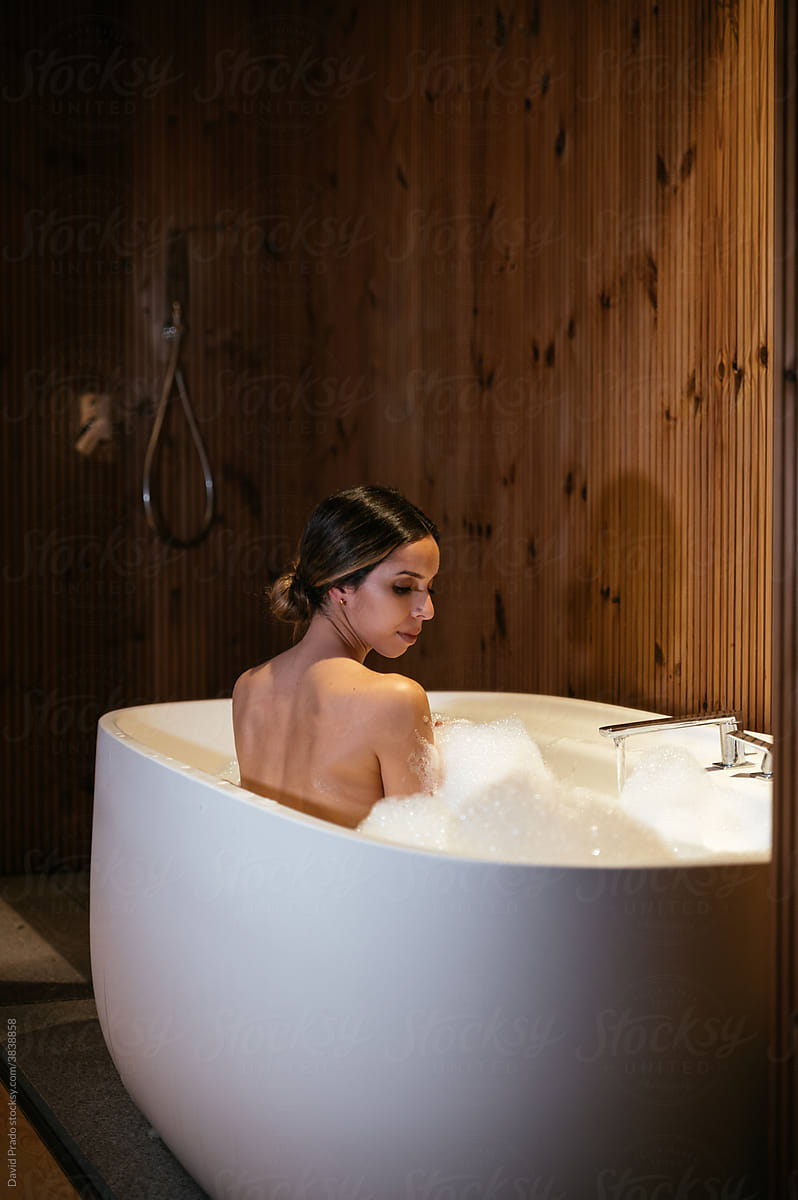Woman in bathtub touching hair