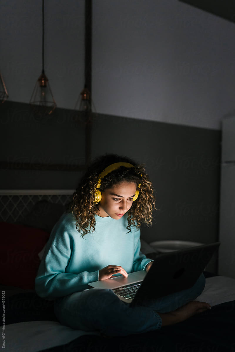 Young woman watching video on netbook at night