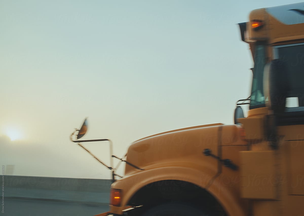 Out of focus school bus drives through the fog