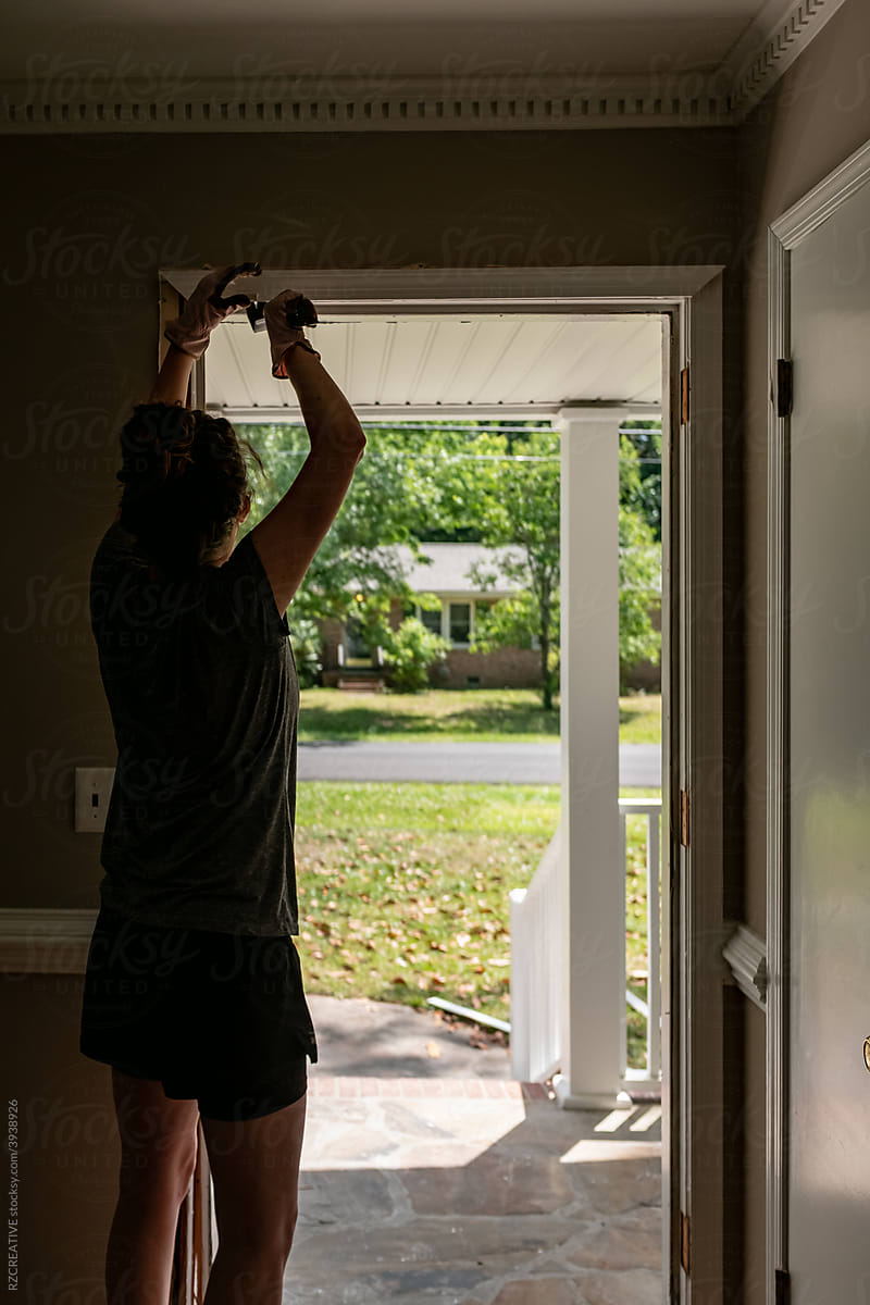 Woman replacing front door.