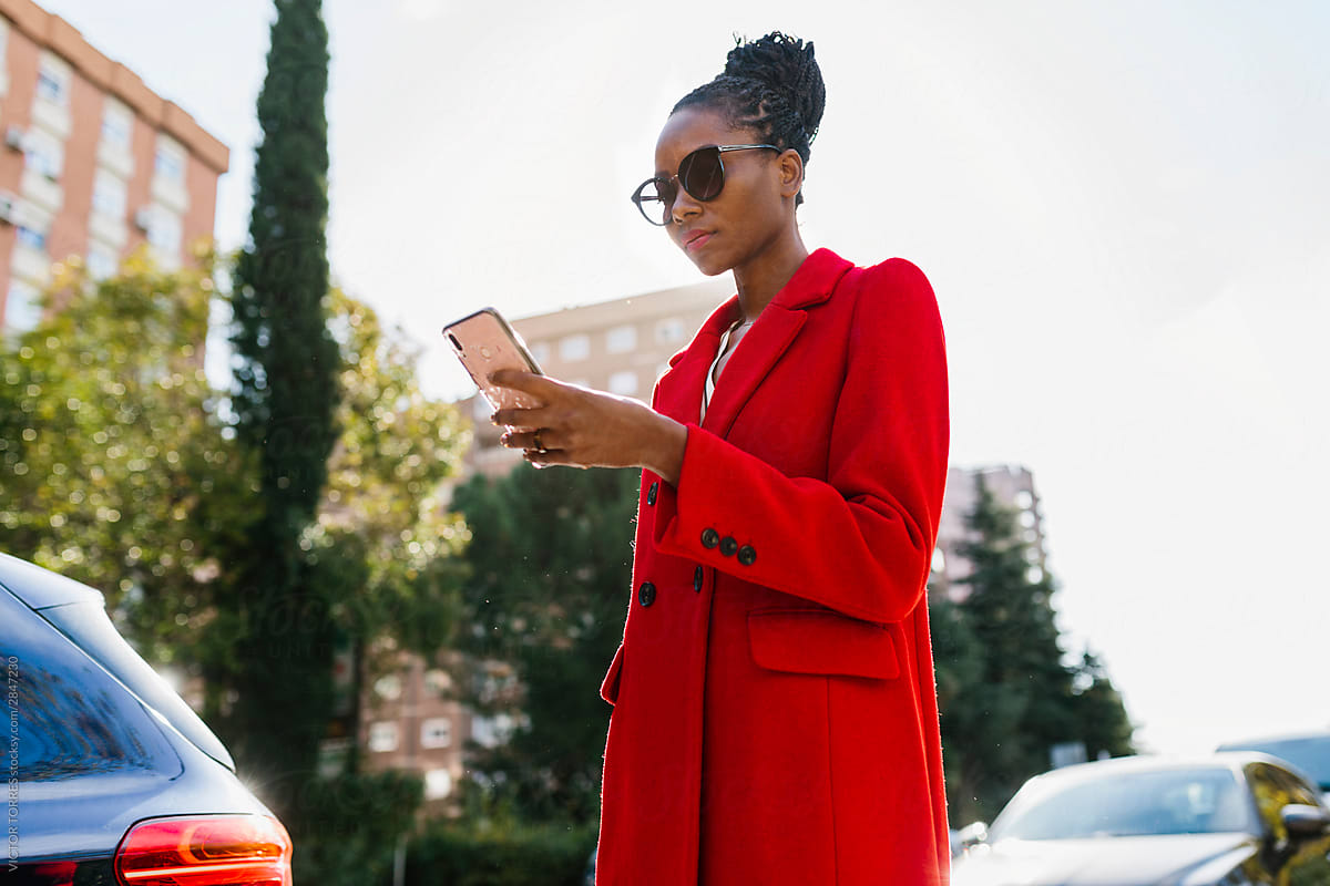 Concentrated elegant woman browsing smartphone in road