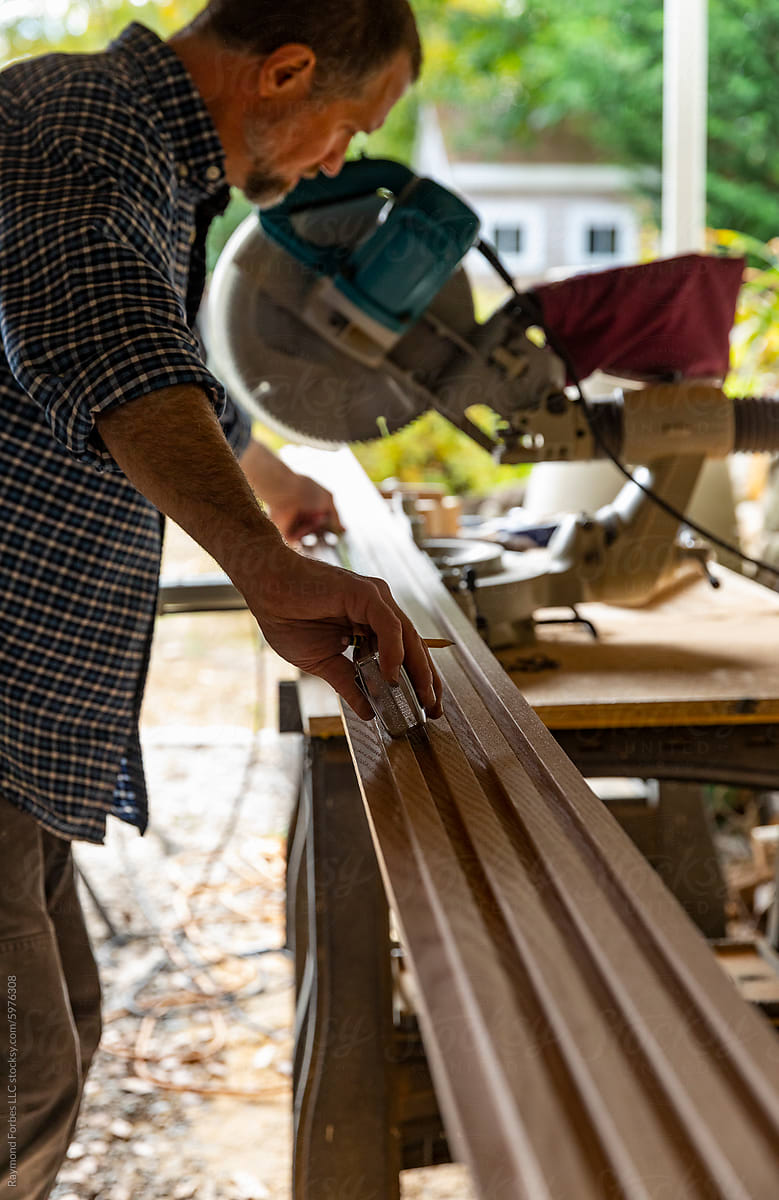 Construction Carpenter handyman cutting wood with saw