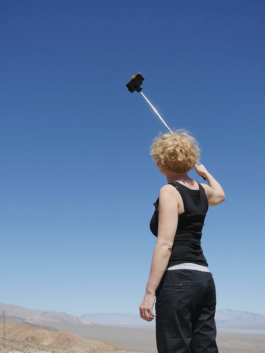 Back view of woman taking selfie