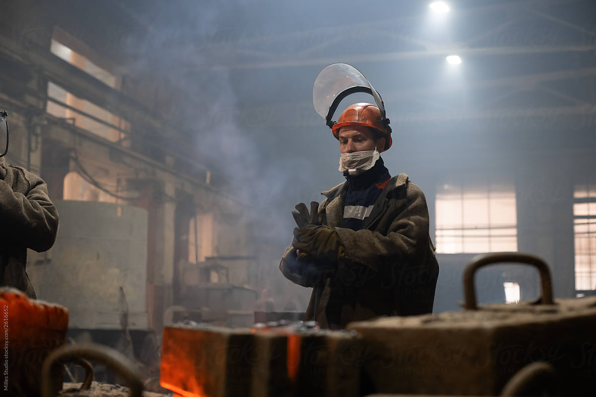 Foundry worker putting on gloves in workshop