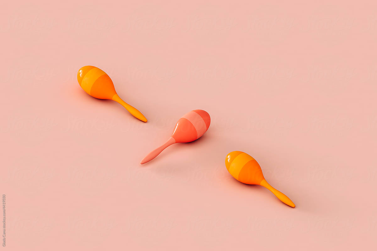 three colorful maracas on a pink background