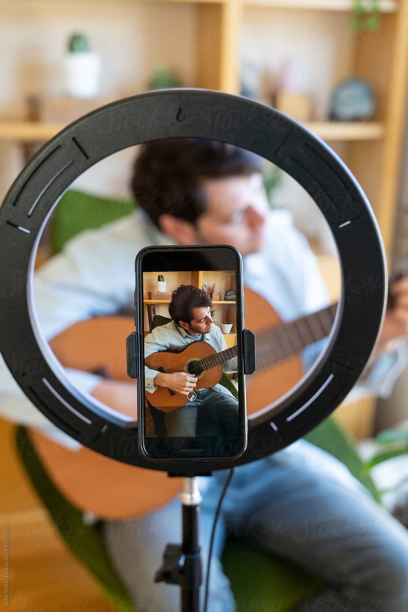 Close-up of Man shooting a video playing guitar