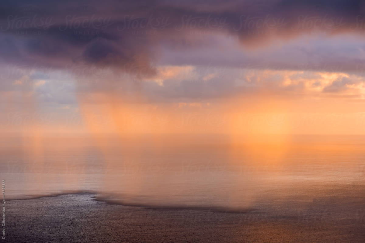 Rain curtain on the sea at sunrise.