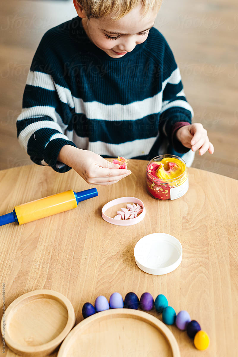 Boy playing with play dough indoors