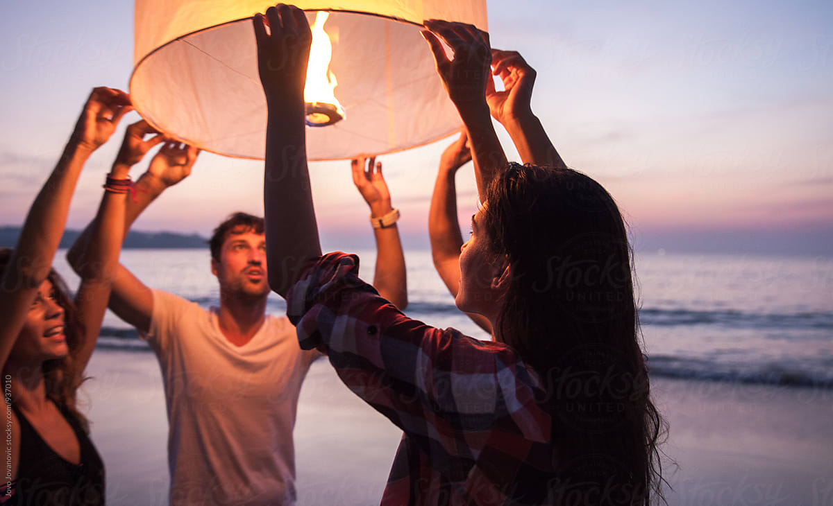 Group Of Friends Releasing A Lantern At The Beach In Thailand By Jovo 
