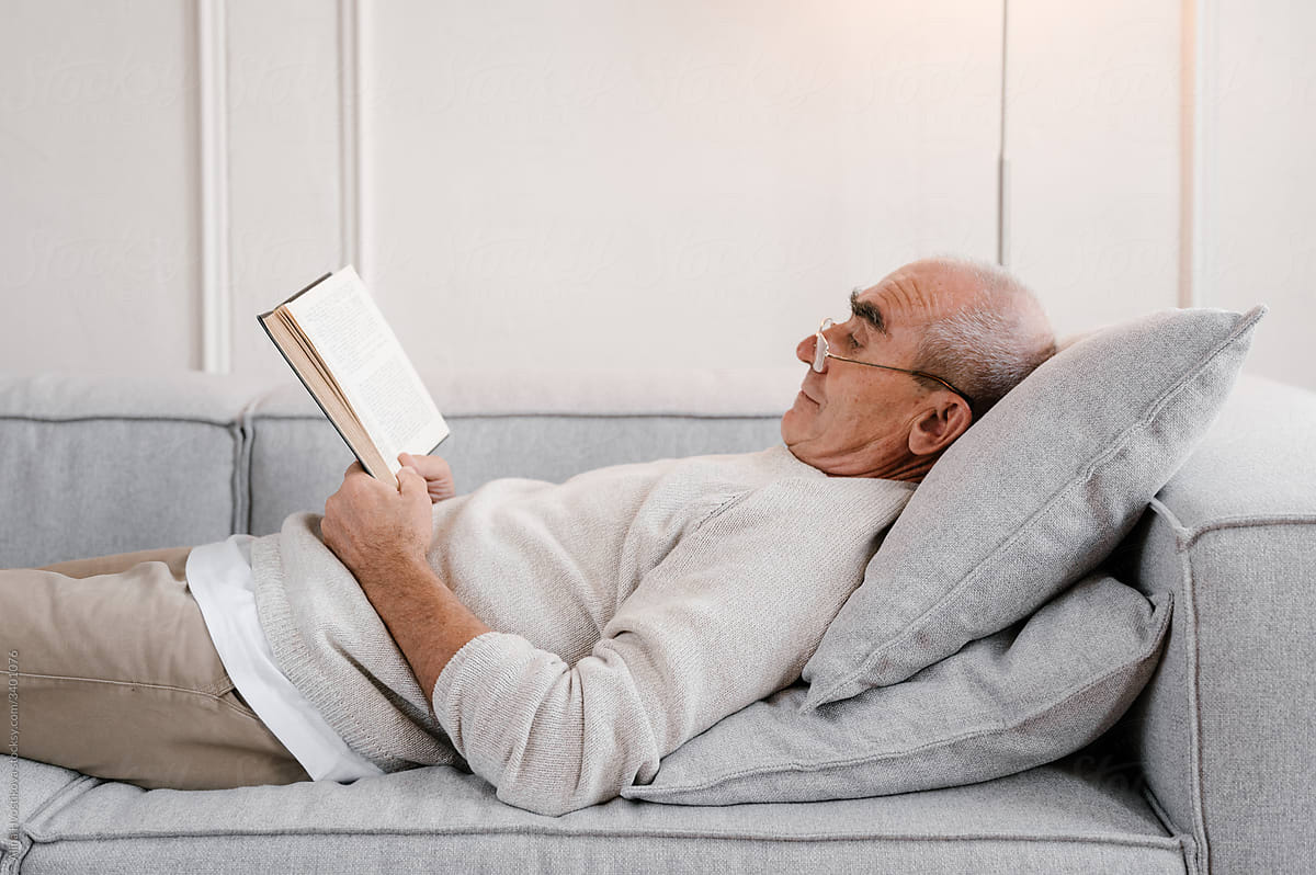 Senior man reading a book  on sofa