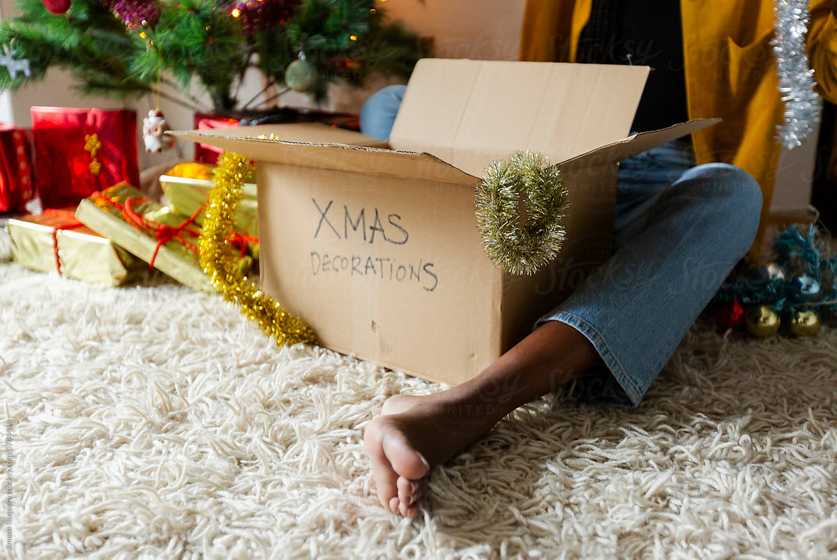 Crop of Anonymous woman\'s feet on the floor putting Christmas decorati