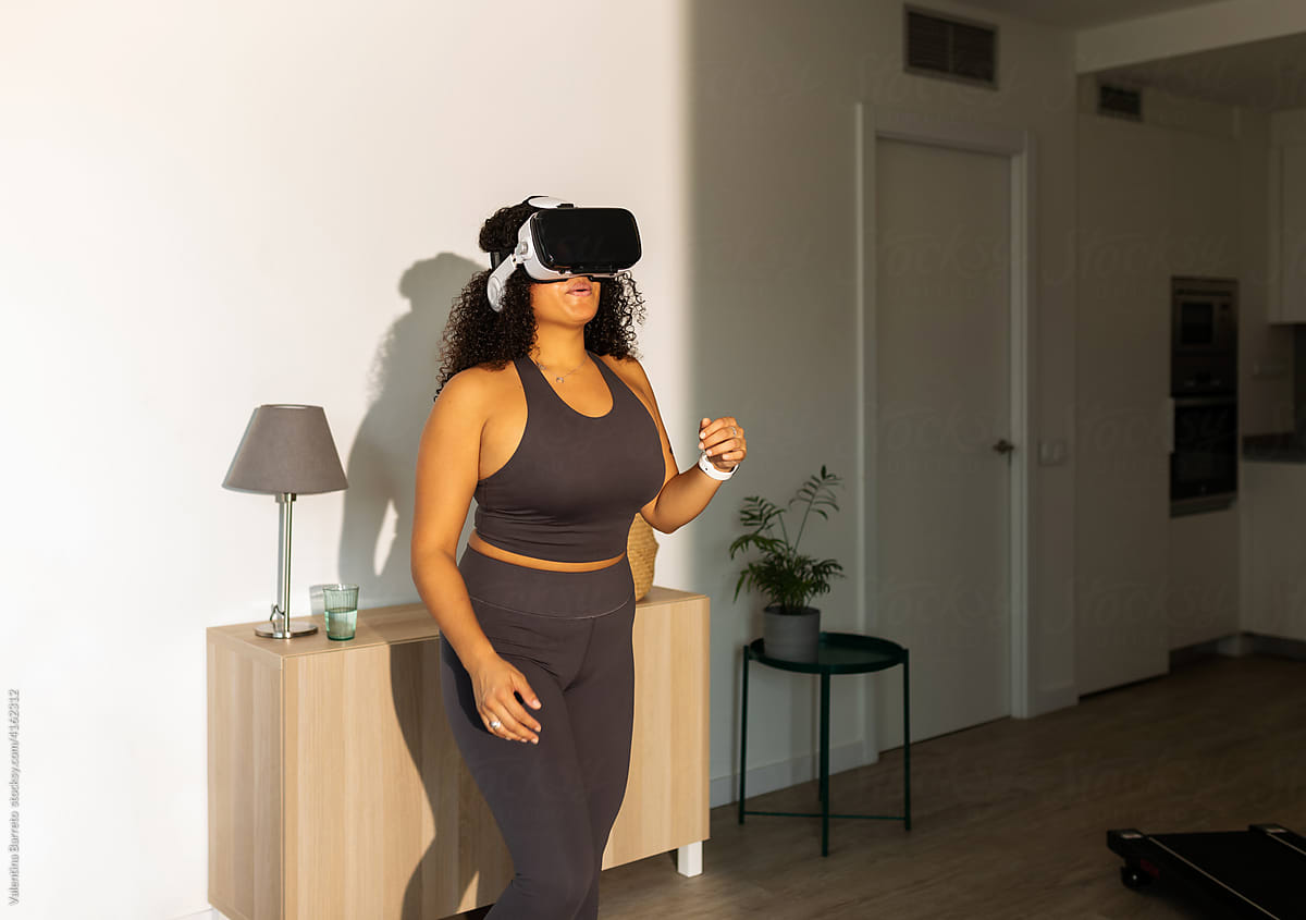 Excited woman with virtual reality glasses at home