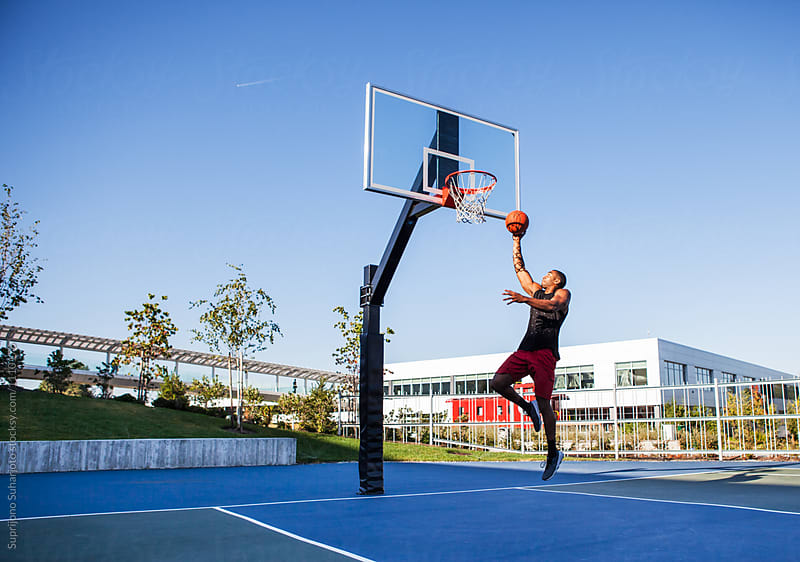 African American man playing basketball on an outdoor court