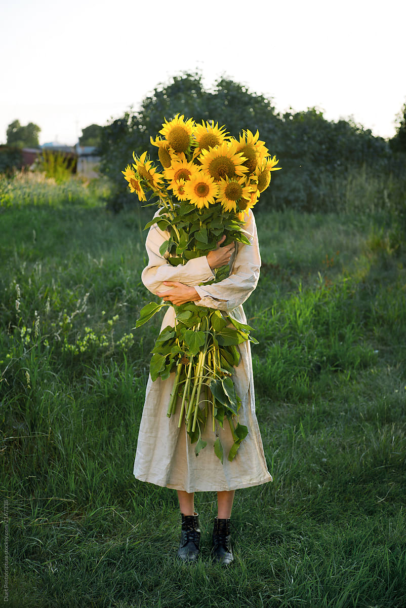 Girl holding a large bouquet of sunflowers