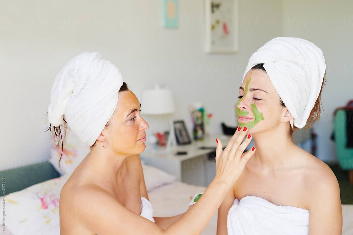 Friends applying face masks at home.