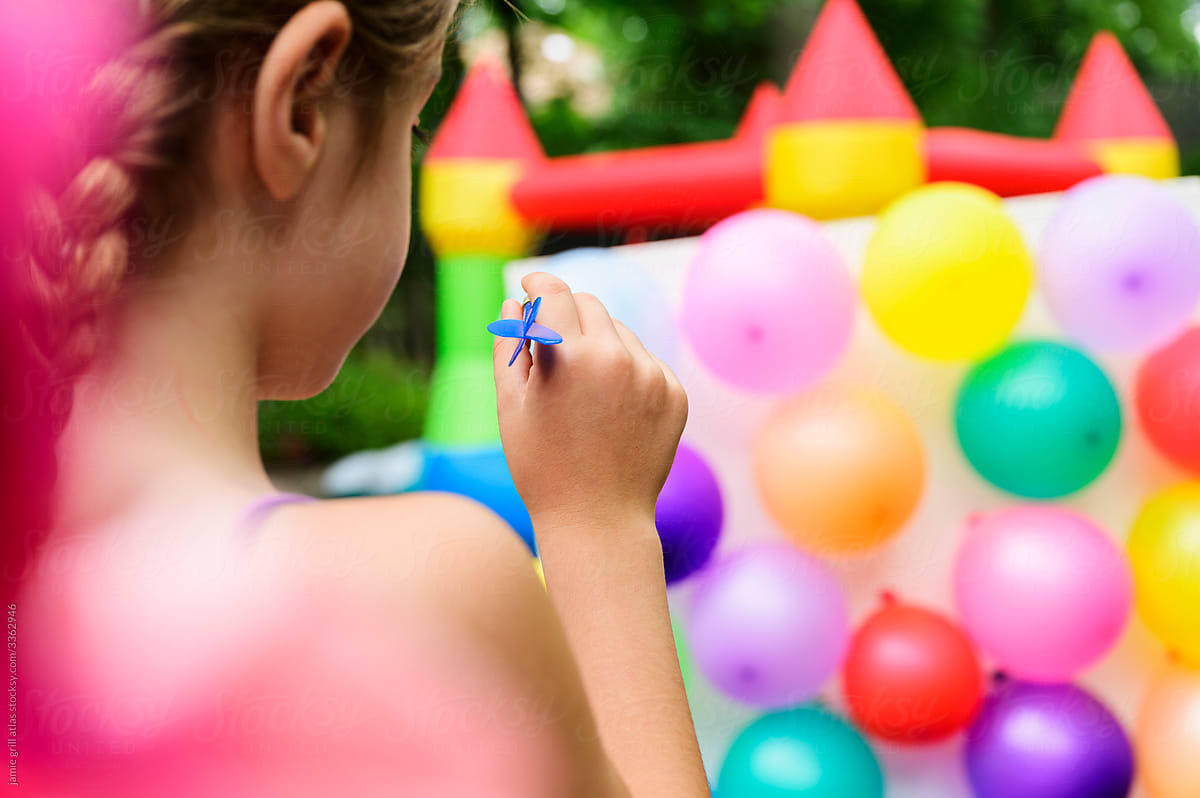 Girl About to Throw a Dart at Balloon Wall