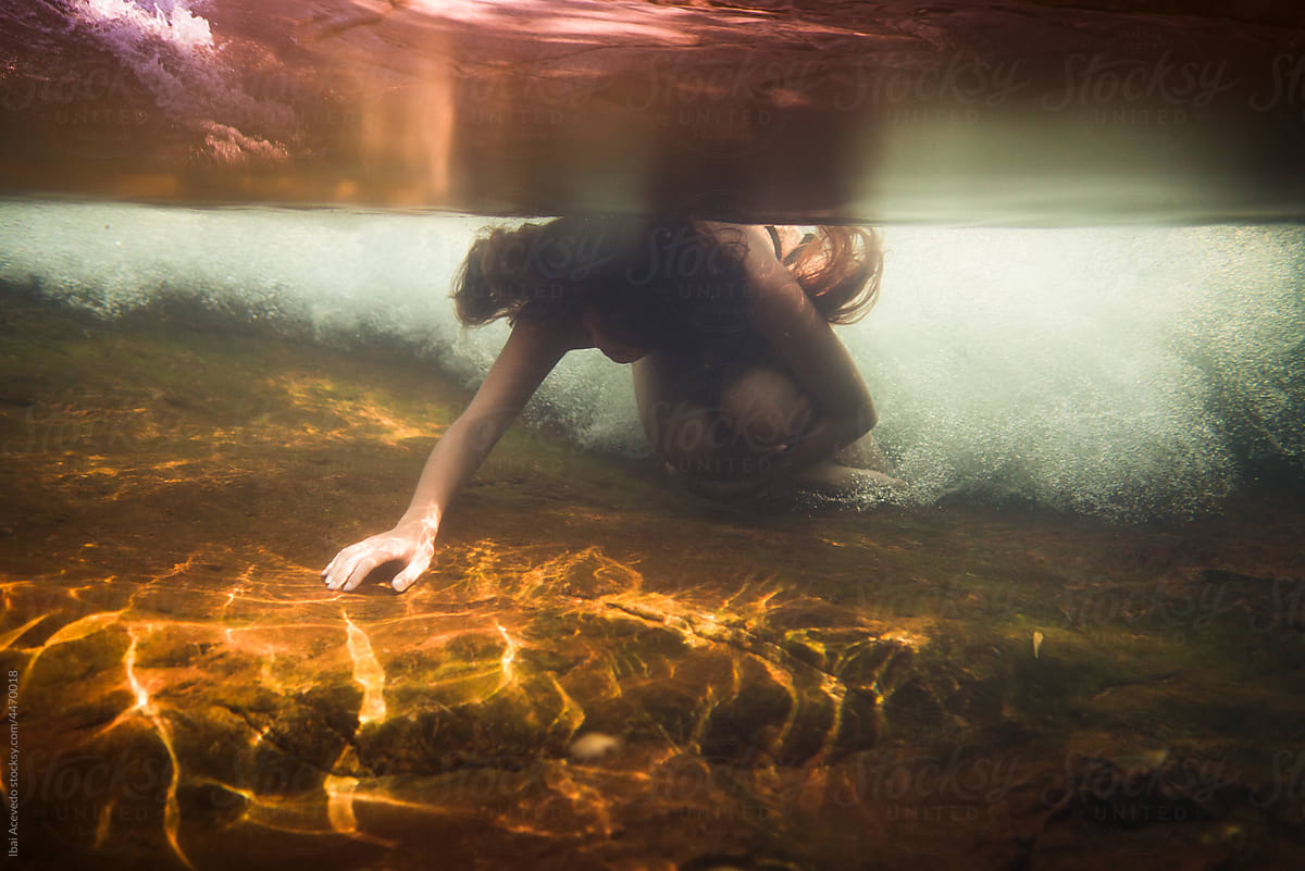 Underwater portrait of woman with river stream