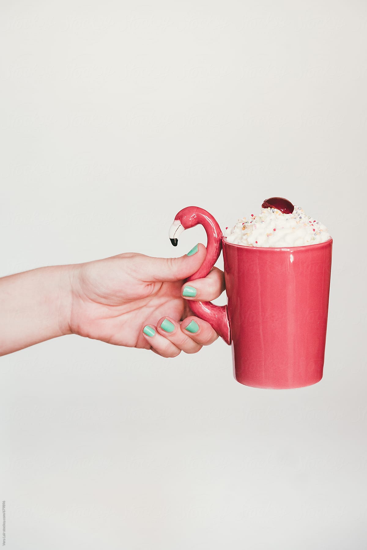 Hand holding a flamingo mug
