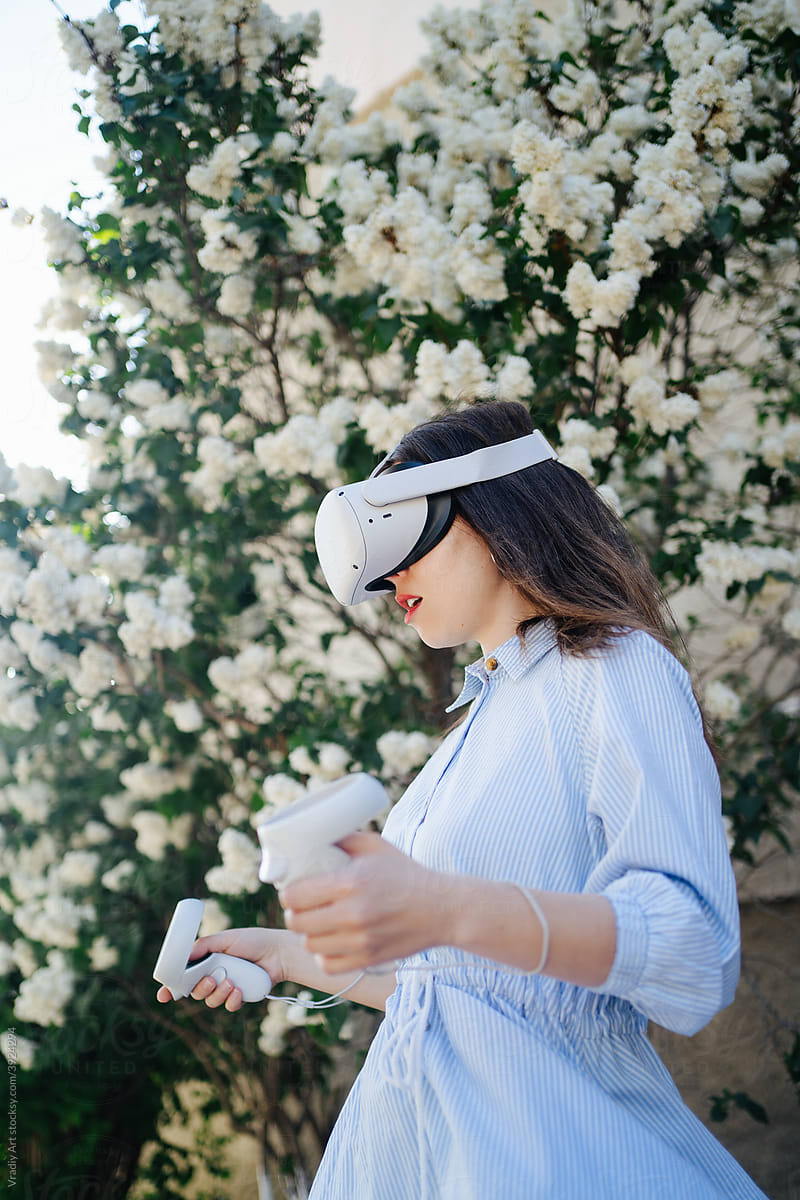 Woman in VR headset playing videogame outside