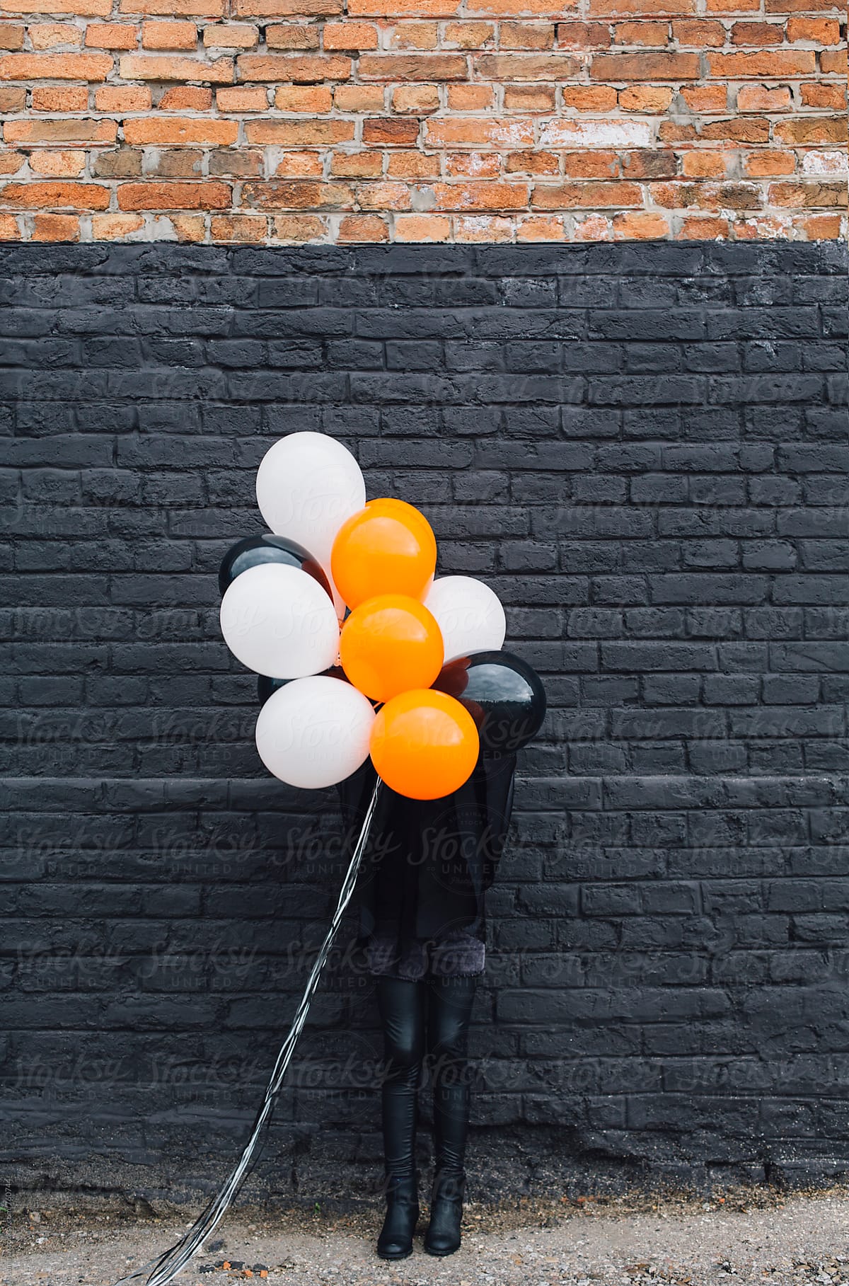 Girl in a Witch Costume Holding Balloons