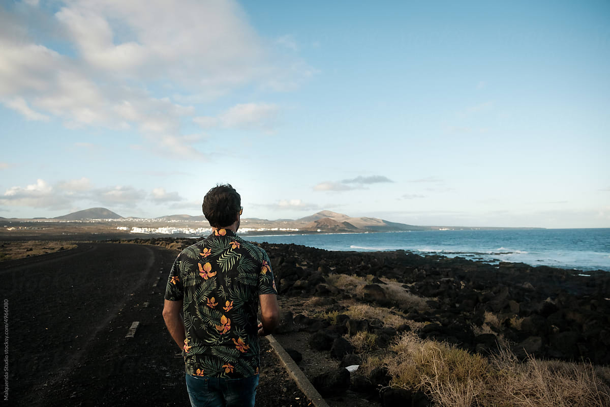Traveler man walking in volcanic landscape
