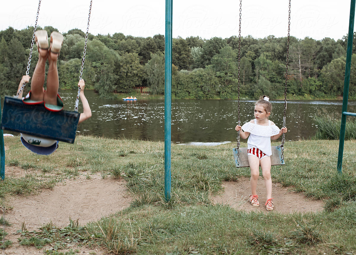 little, cute girl swings on a swing