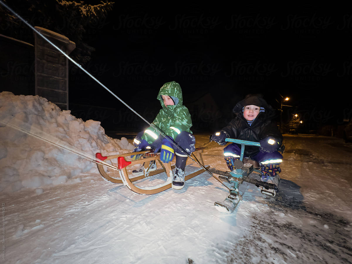 Children are sledding during the night