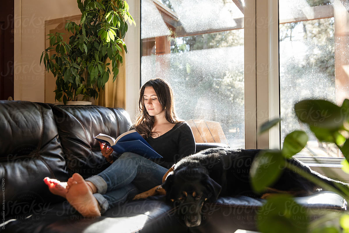 A Woman Reading Beside Her Dog