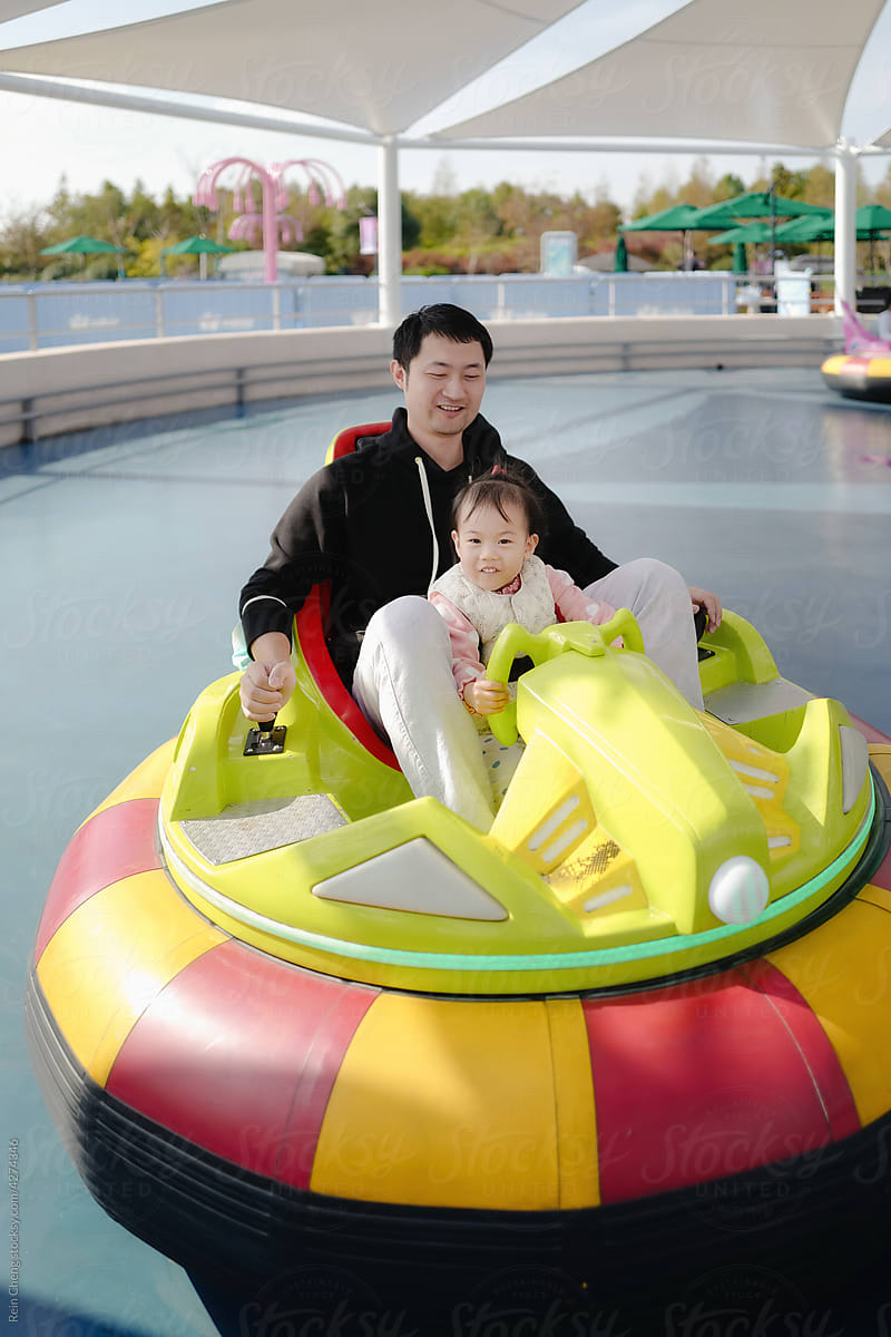 Asian baby and dad drive bumper car