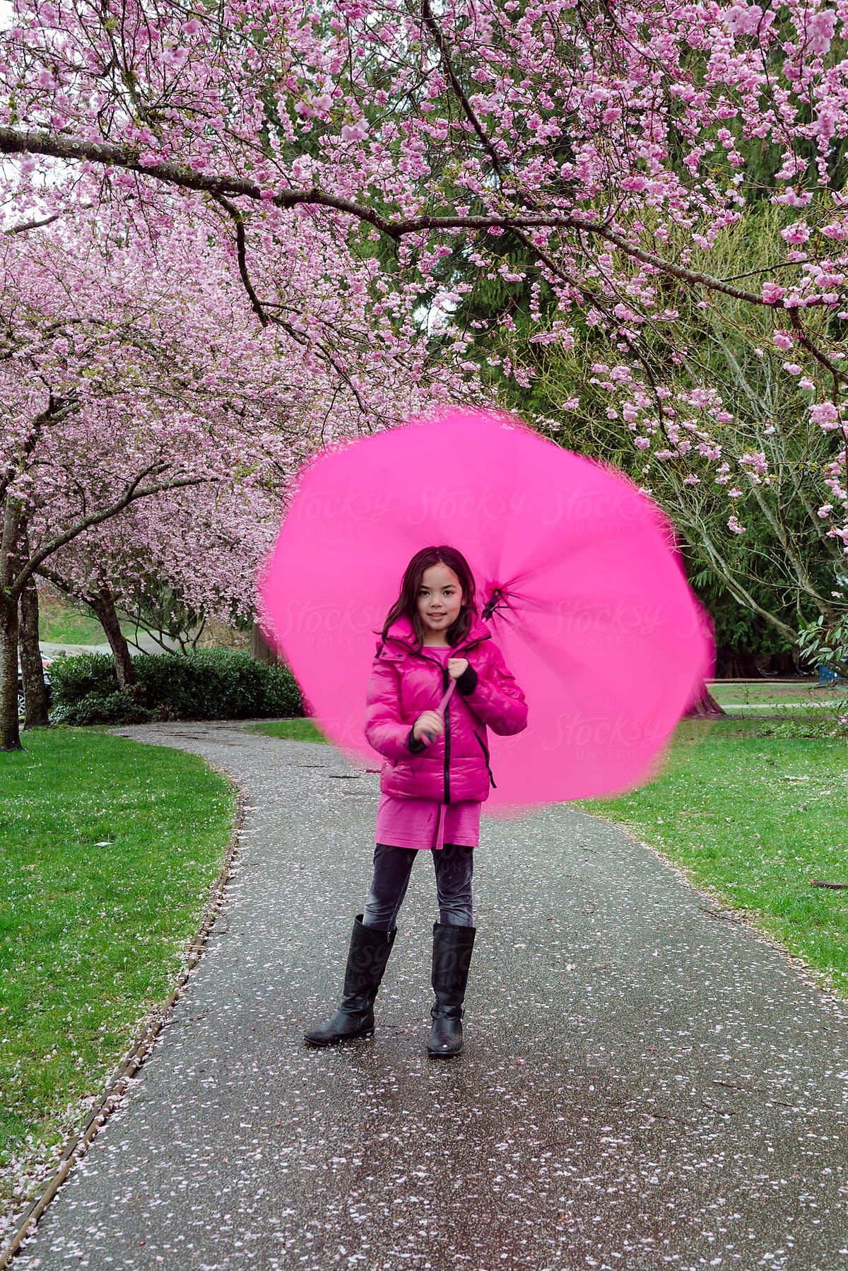 Girl Twirling Umbrella Under Spring Blossoms