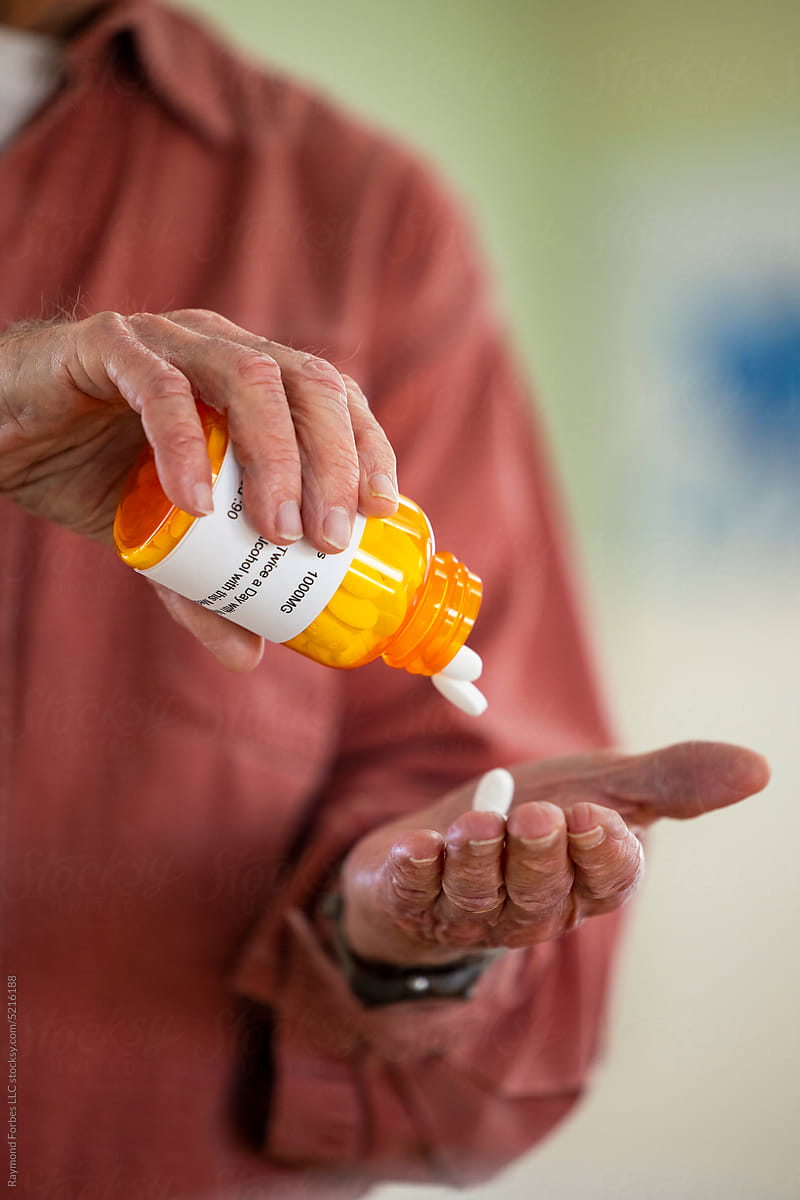 Senior Citizen with prescription pill drop in  hand