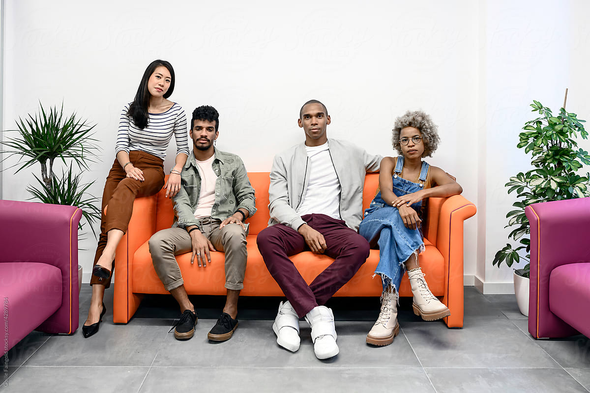 Stylish diverse coworkers on sofa