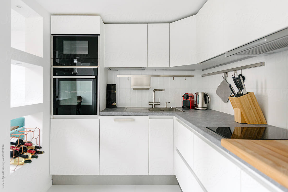 Fully furnished white kitchen cupboard. Minimalist flat