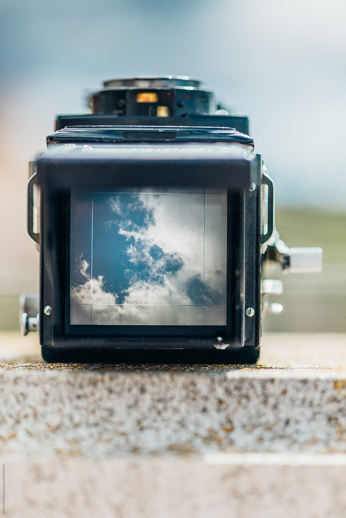 Retro camera focusing on clouds in the sky.