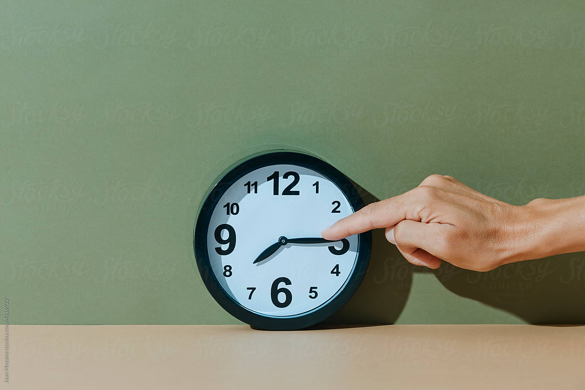 man moves the hands of a clock forward
