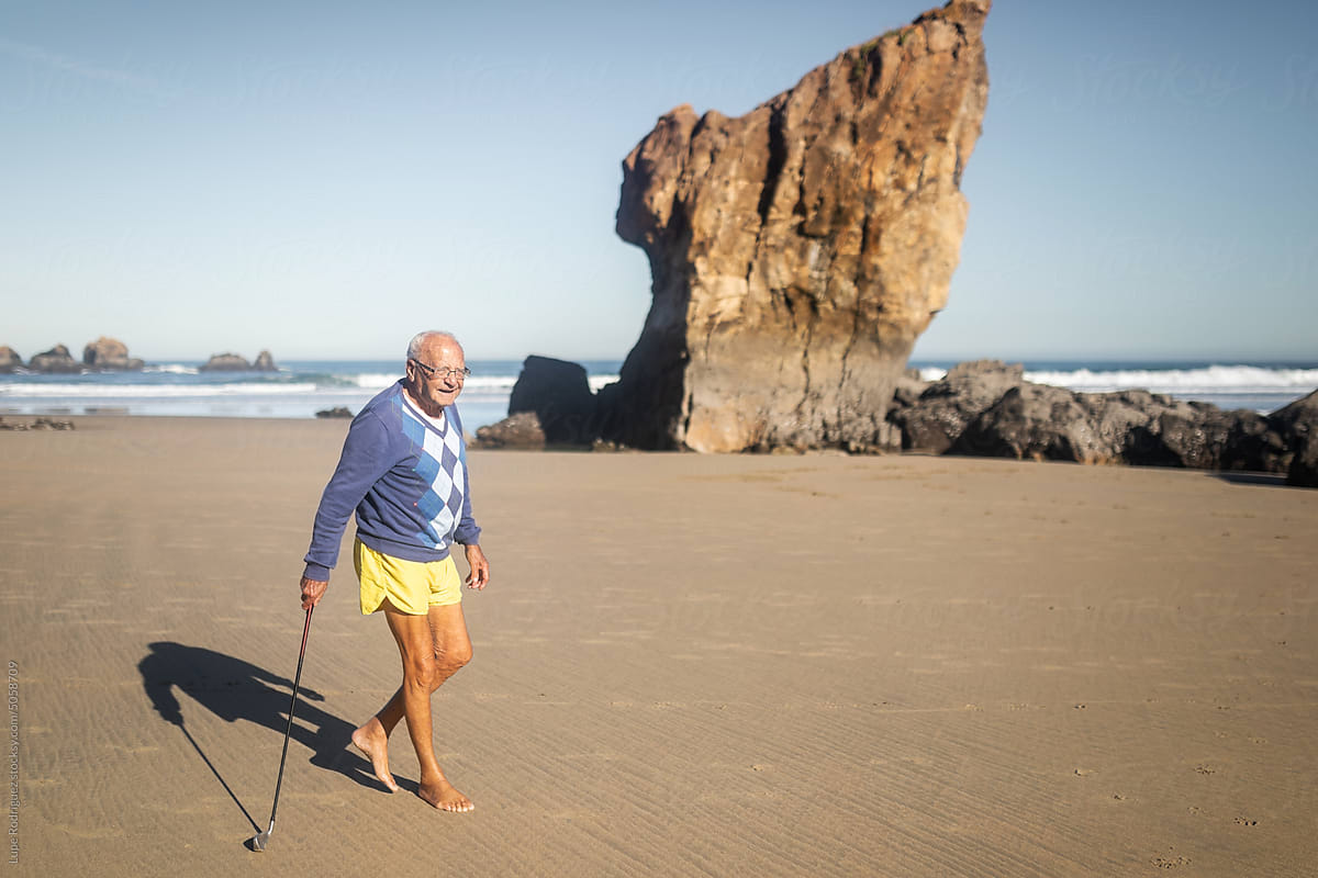 senior man playing golf on the beach