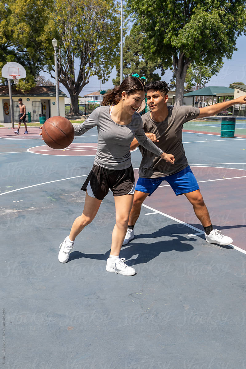 Teenagers playing basketball together outdoors