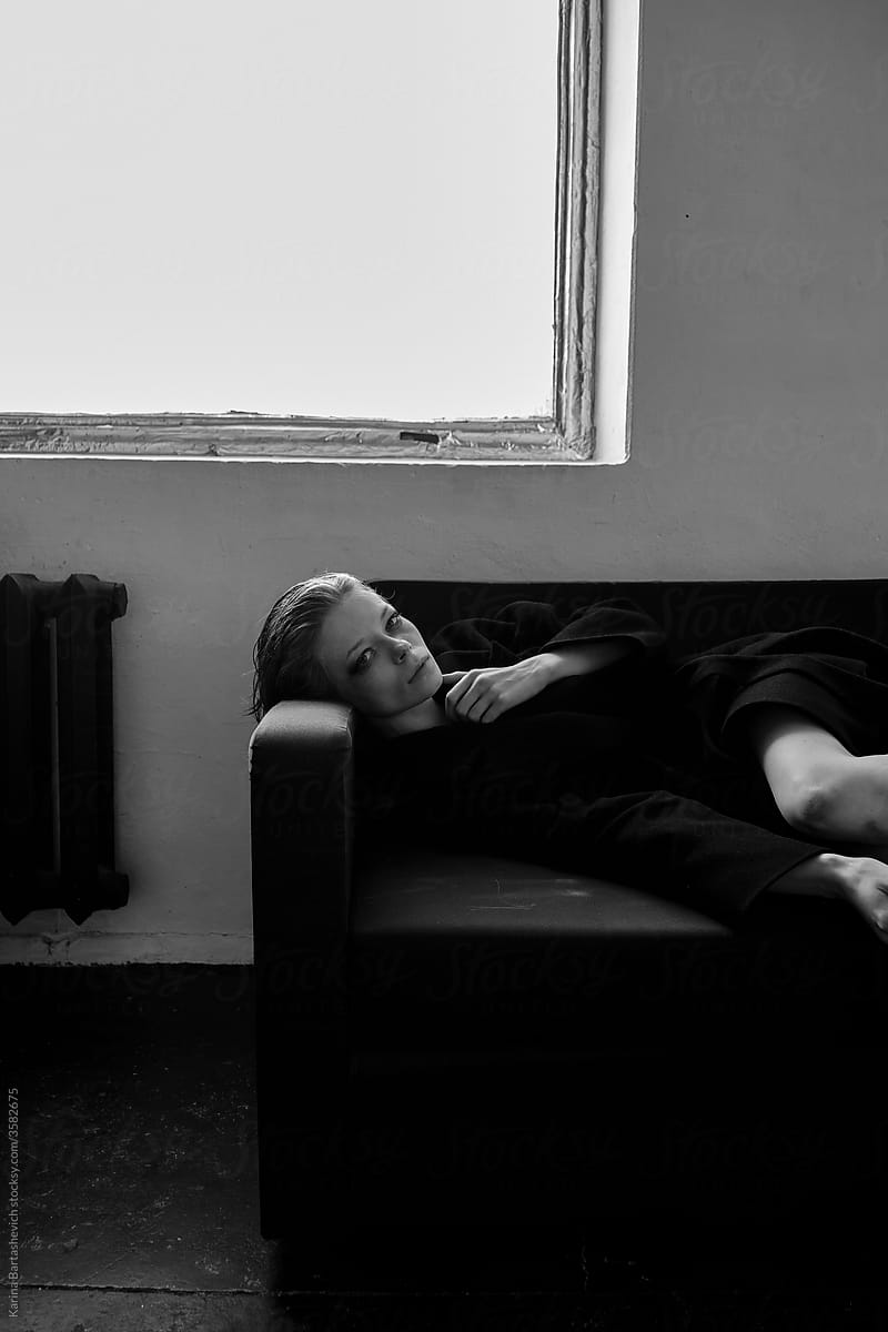 artistic black and white portrait of a girl lying on a sofa