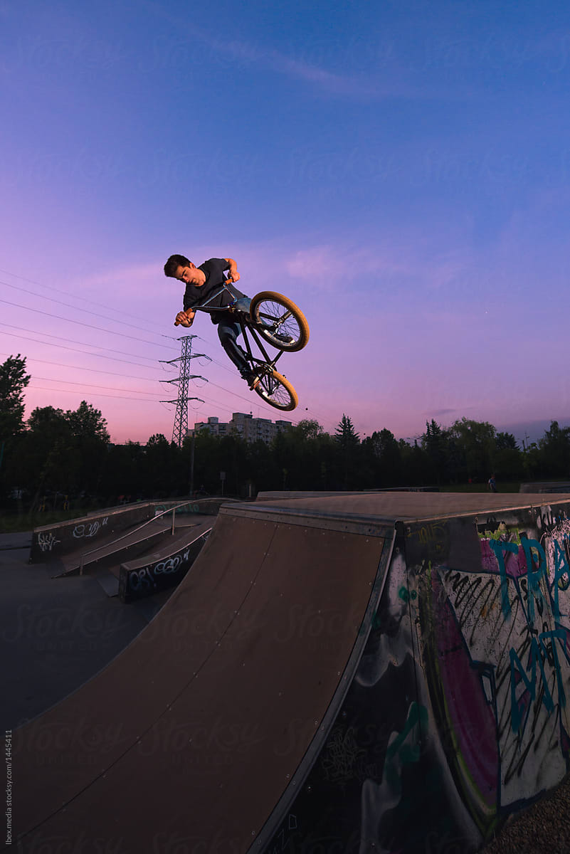 BMX rider performing midair stunts in skate park