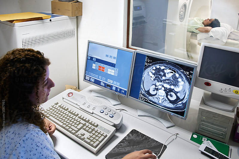 Healthcare professional preparing computer for ct scan procedure