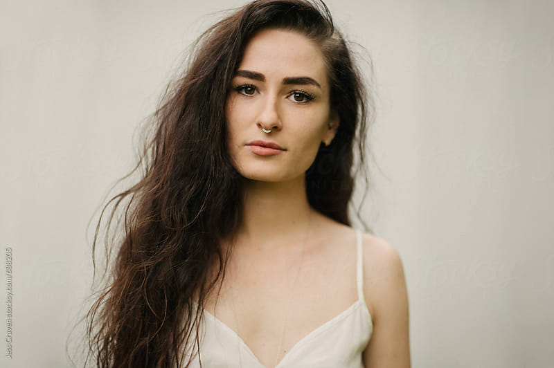 Female With Long Curly Dark Hair And Septum Nose Piercing With Cream 8584