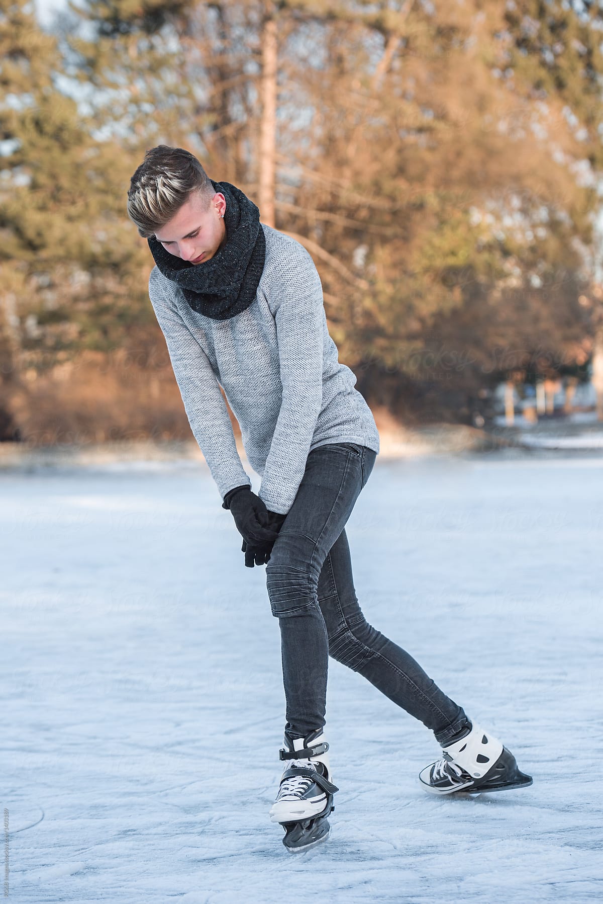 Teenager wearing black scarf and gloves ice skating outdoor