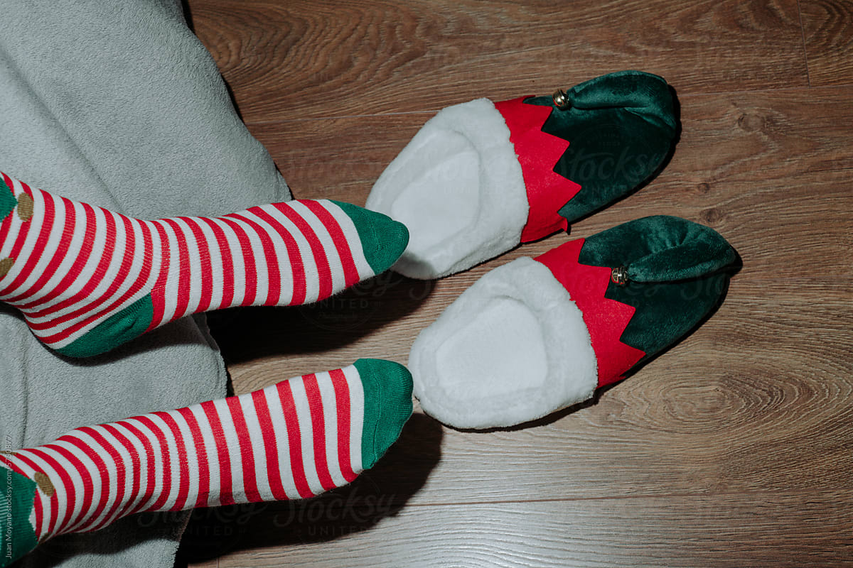 man in bed wearing elf white and red striped socks